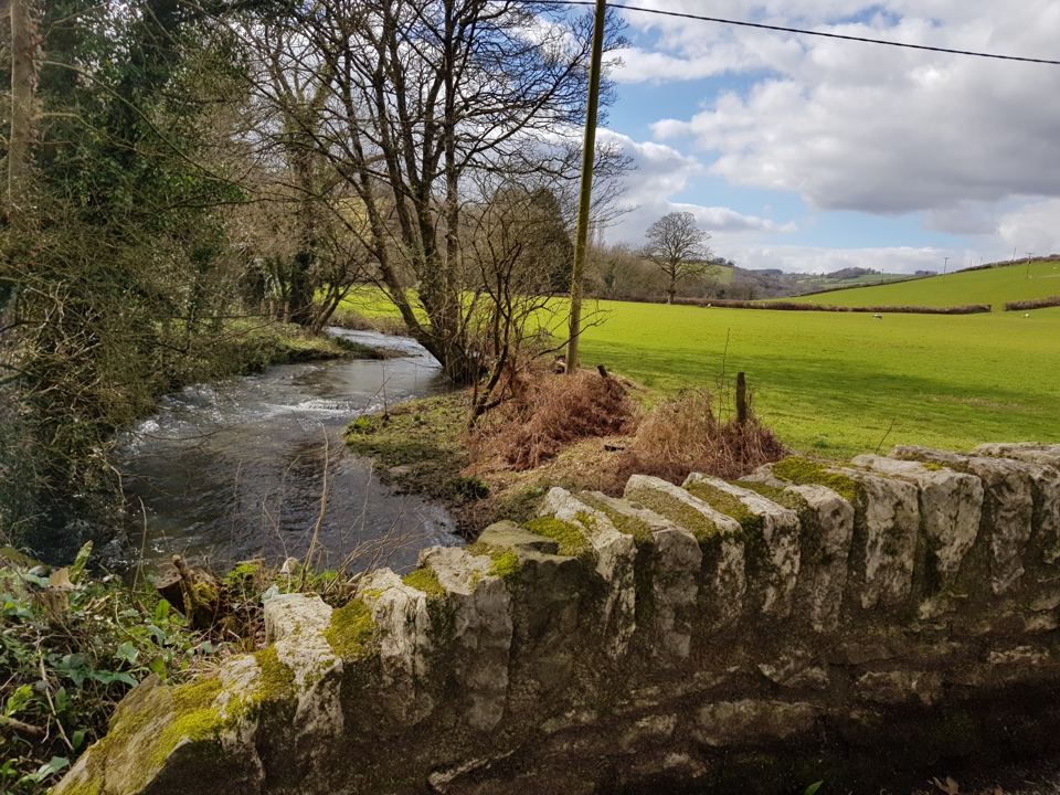 Stream and stone wall by the fields