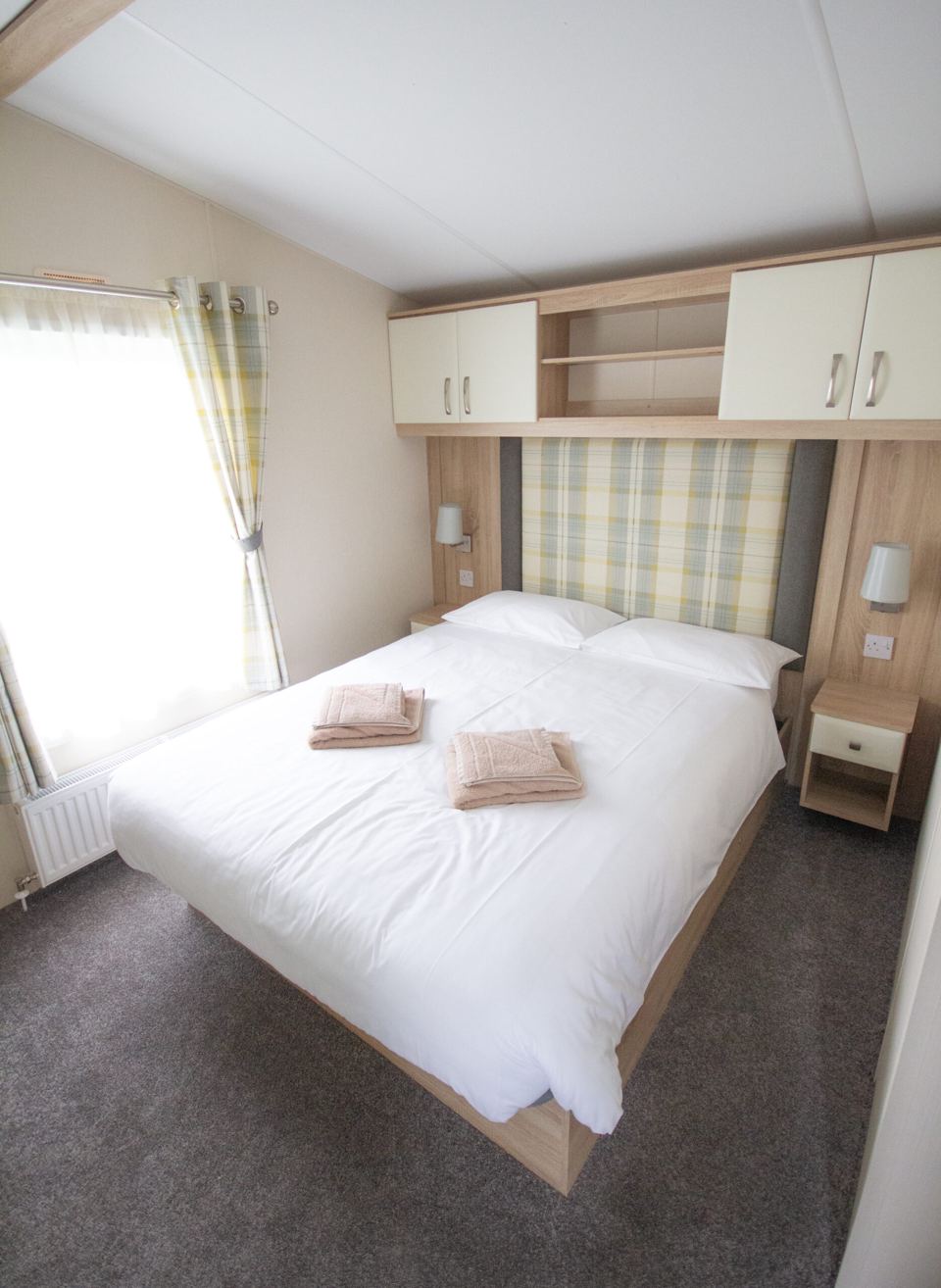 Caravan bedroom with checked curtains