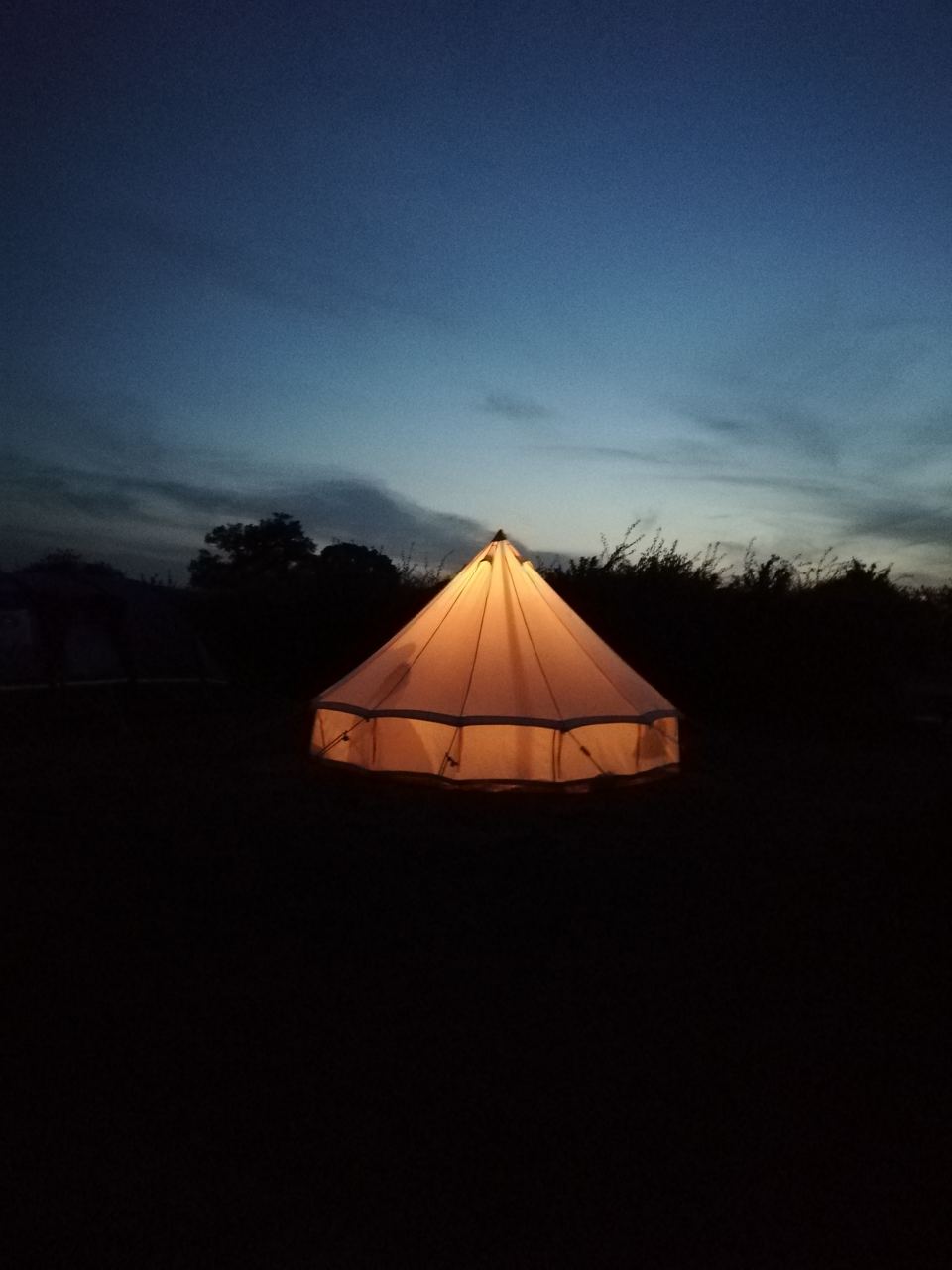 Bell tent lit up at dusk