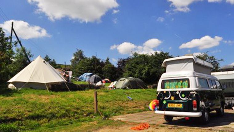Tents and campervan on the field