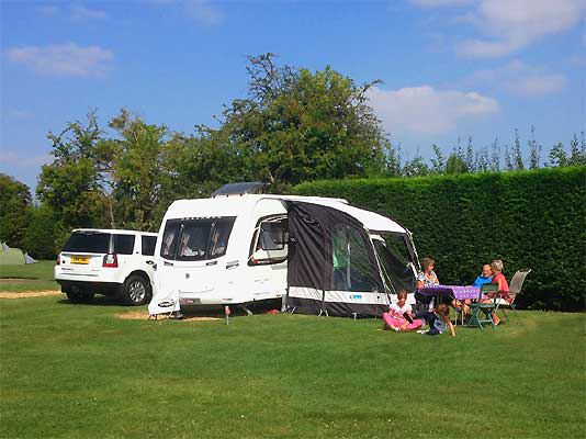 Caravan and awning by a hedge