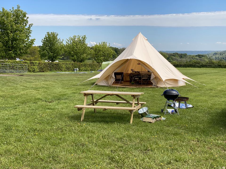Bell tent with picnic bench and barbecue