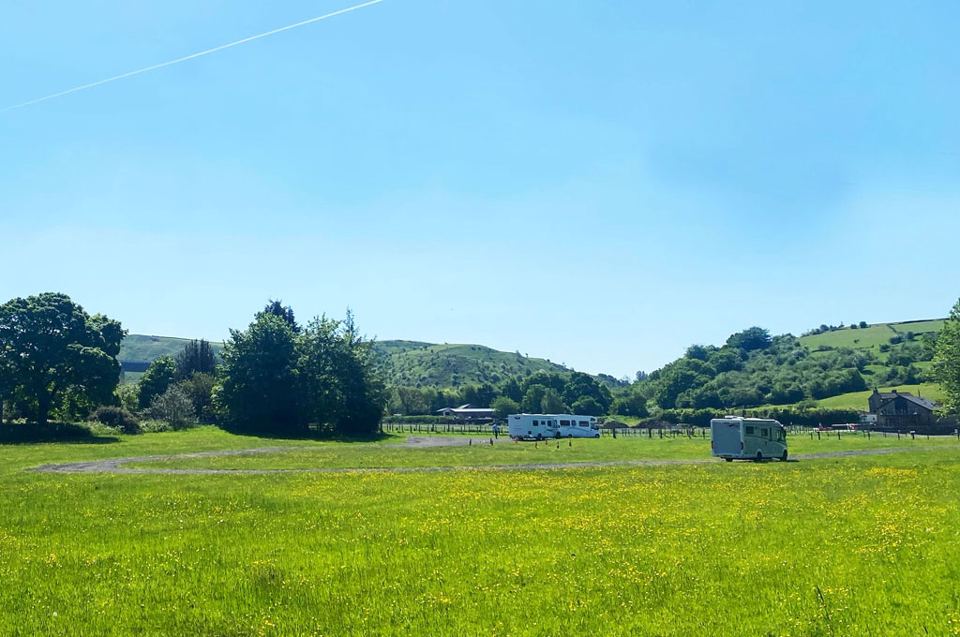 Meadow with vans in the distance
