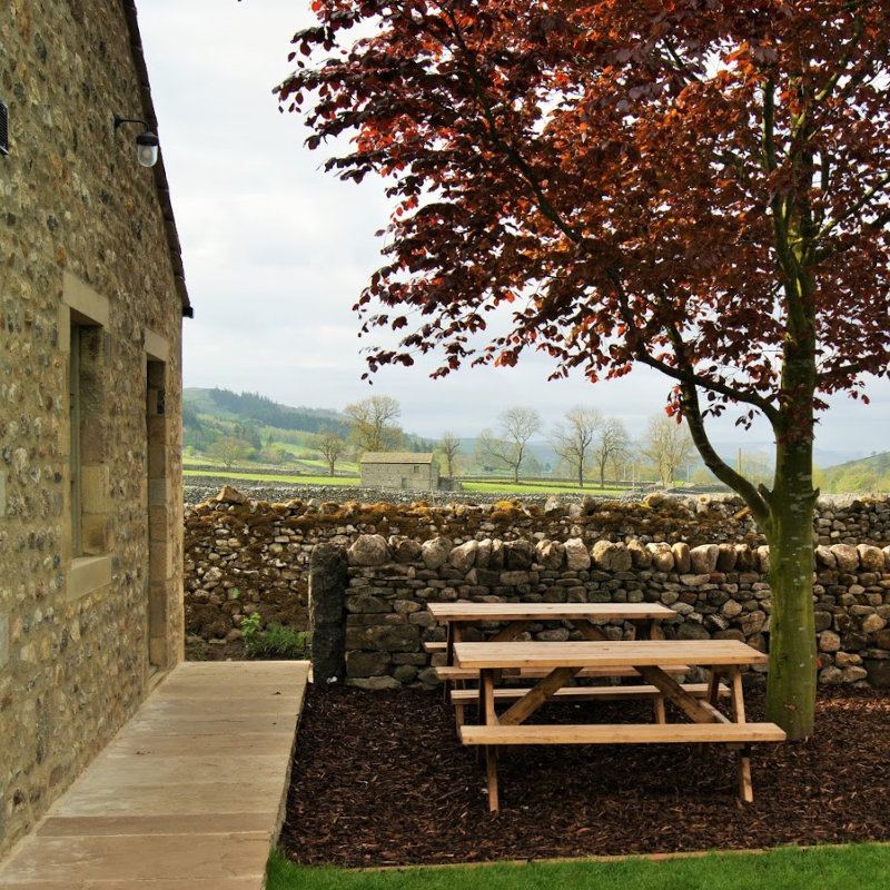 Picnic bench by the stone wall