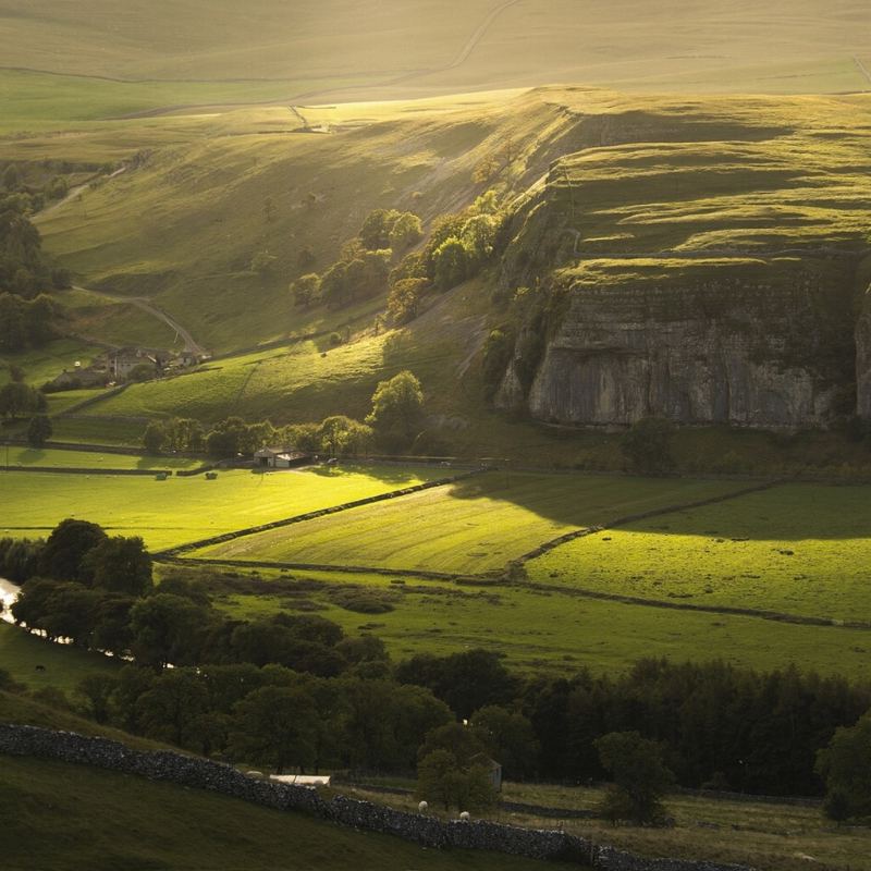 Crag and fields in evening light