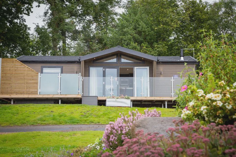 Lodge with deck and flower beds