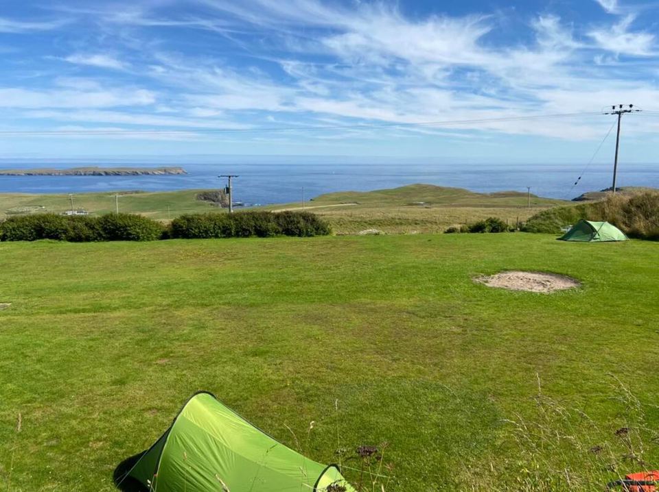 Tent on grass with sea view
