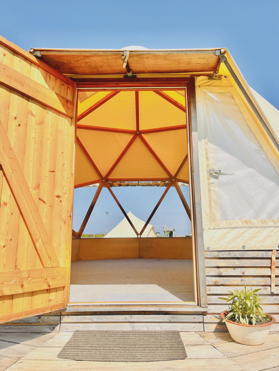 Bell tent doorway with a potted plant