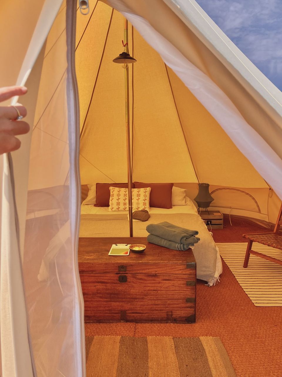 Inside a bell tent with rugs and cushions