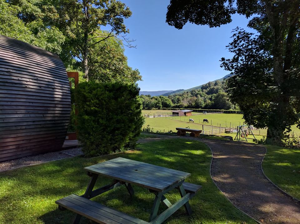 Pod and picnic bench with hill view