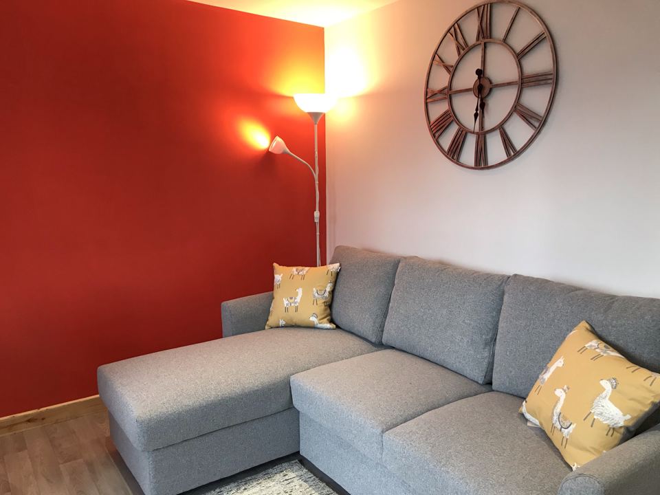 Lounge with grey sofa and clock