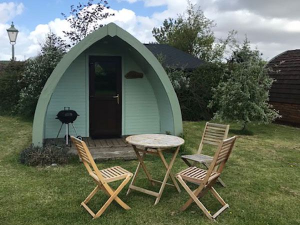 Wigwam pod with chairs and barbecue