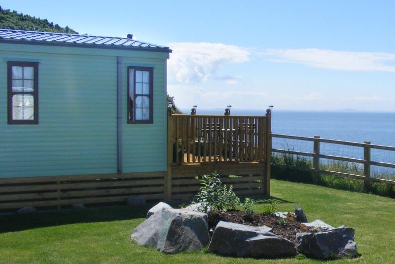 Caravan with decking above the sea
