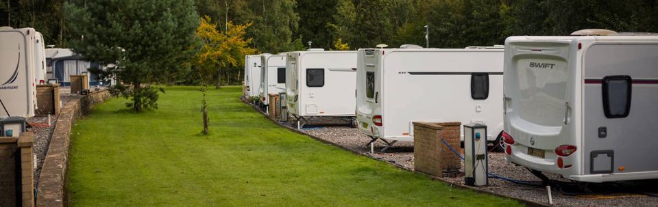 Row of touring pitches with hook-ups