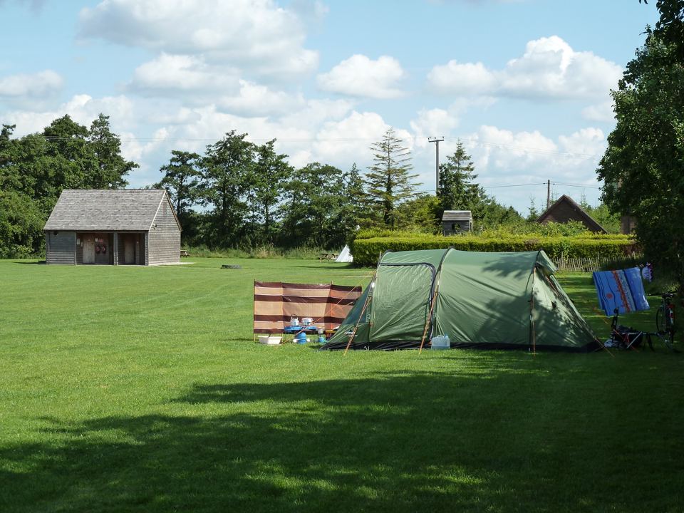 Tent on the grass with facilities block