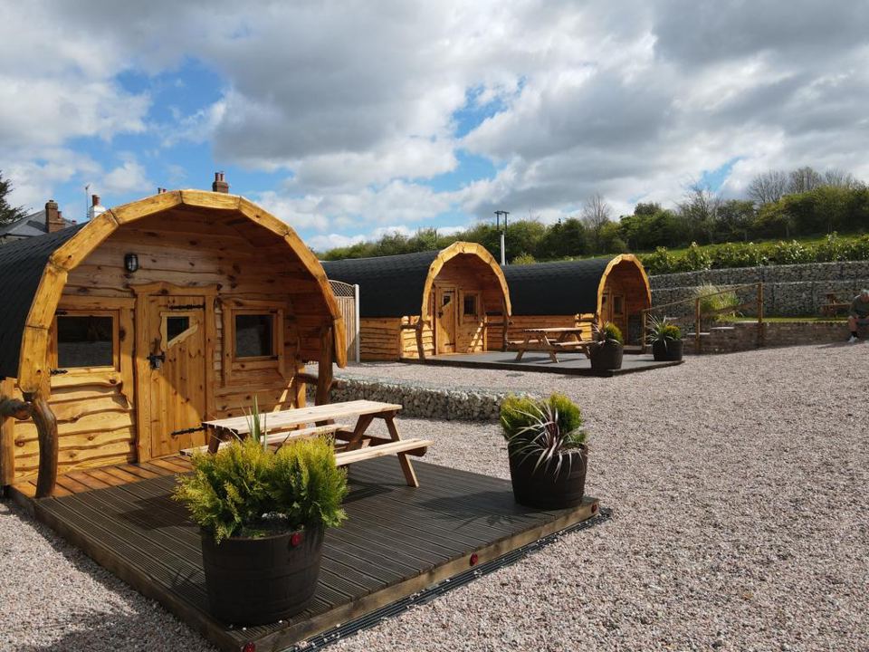 Wooden glamping pods on gravel