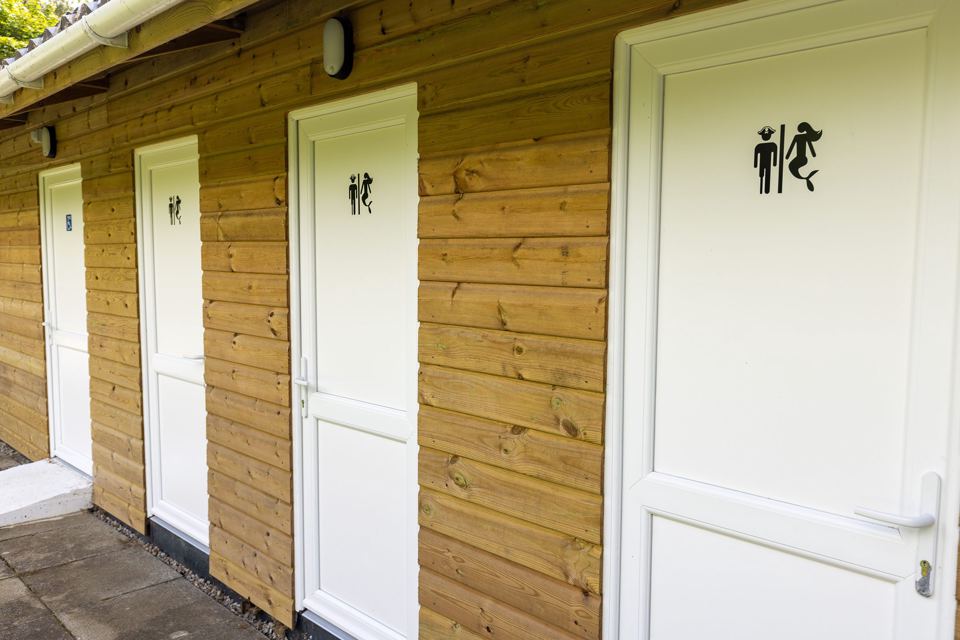 Wooden toilet block with white doors