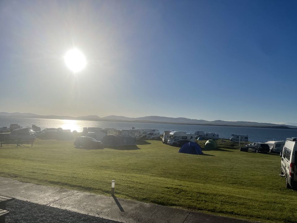Camper vans and tents by the water