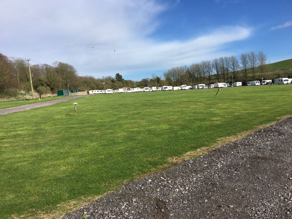 Level grass field with caravans