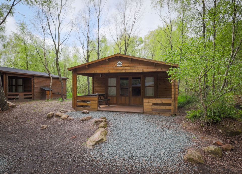 Log cabin with gravel parking