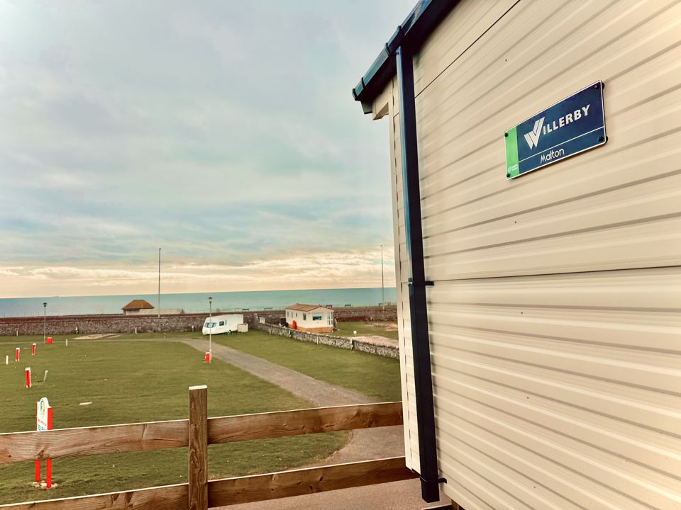 Caravan with sea beyond the park