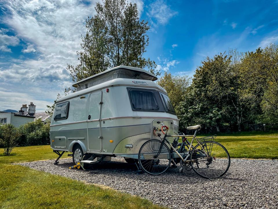 Small caravan and bike on gravel