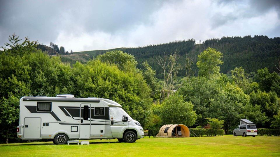 Grass pitches below wooded hills