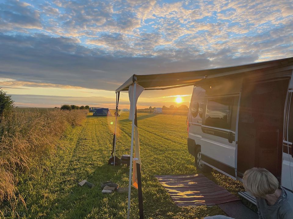 Campervan with awning at sunset