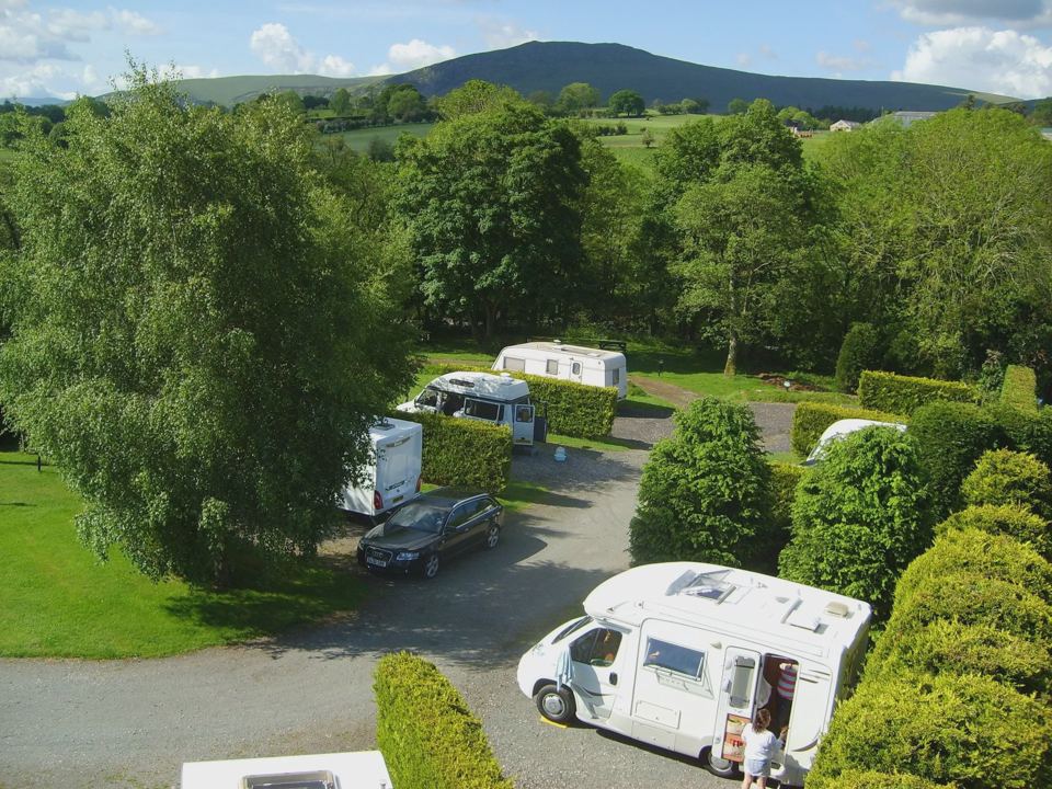 Pitches and motorhome with hills beyond