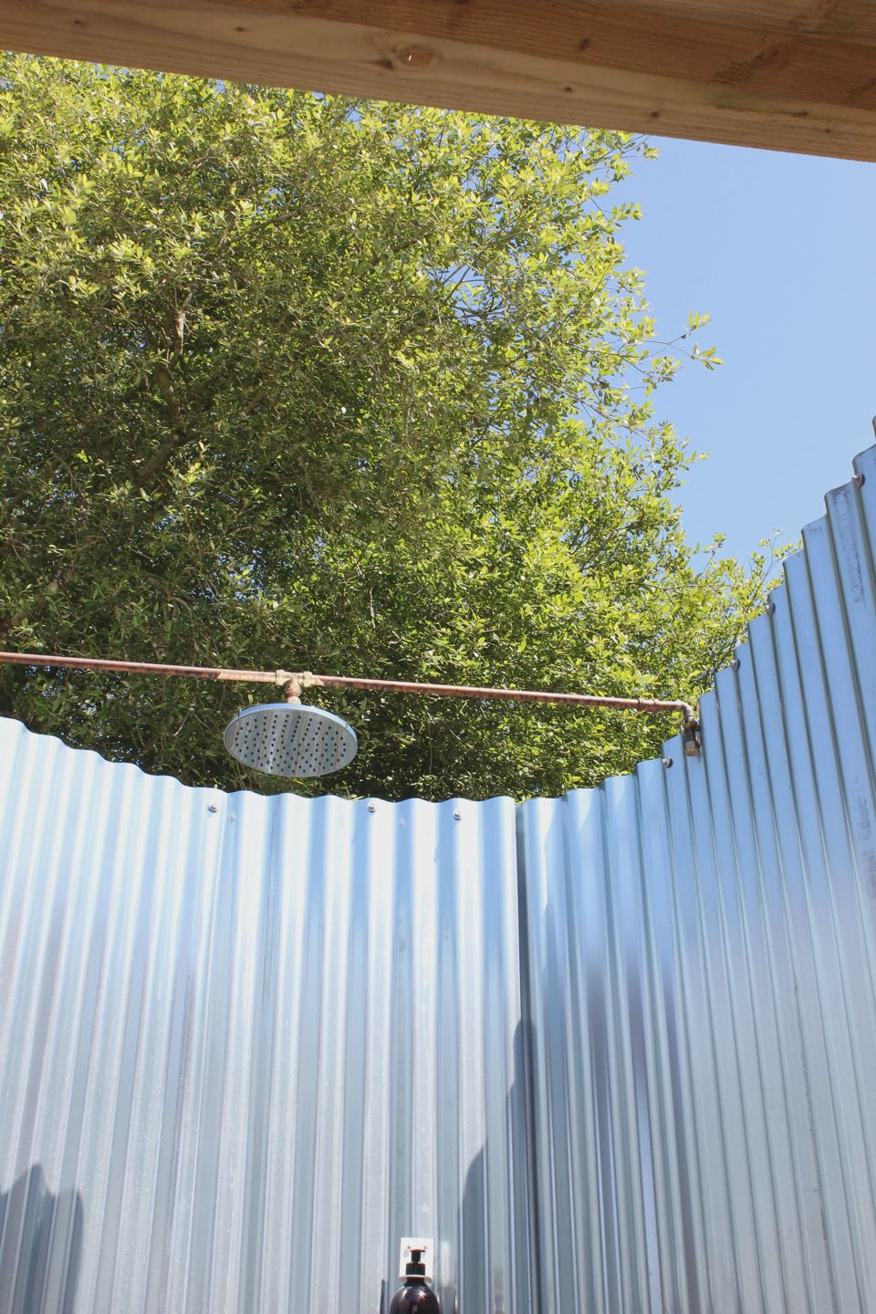 Outdoor shower in a corrugated enclosure