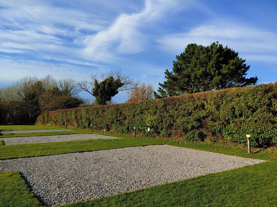Gravel pitches beside the hedge