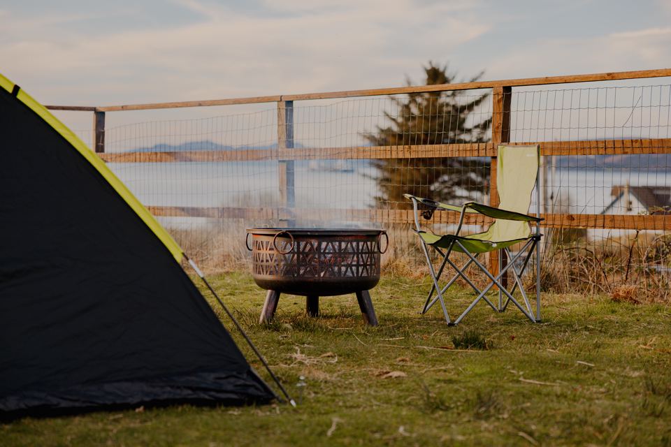 Tent and fire pit by the fence
