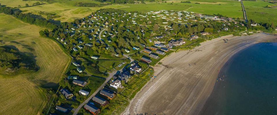 Beach curving past the park