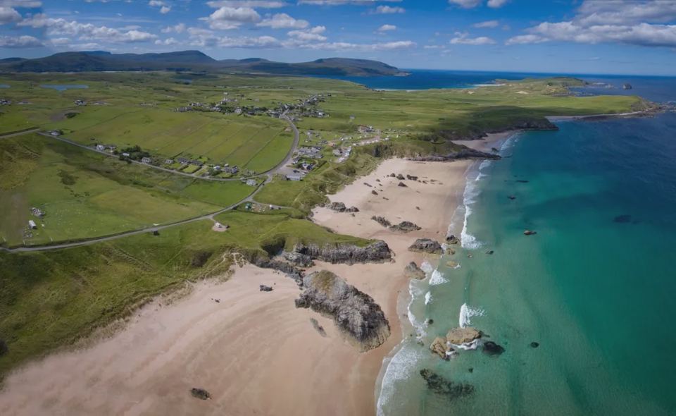 Sandy bay below the site