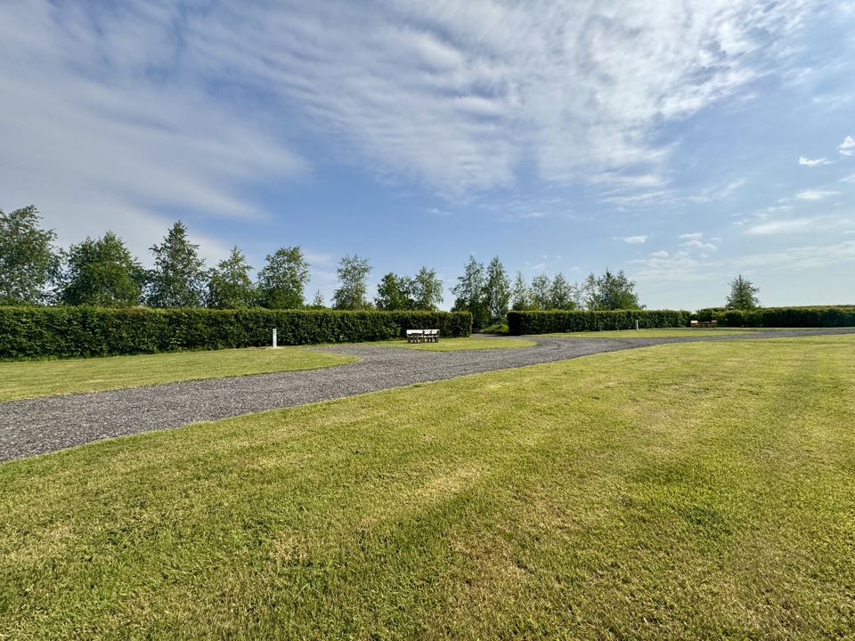 Mown grass beside gravel track