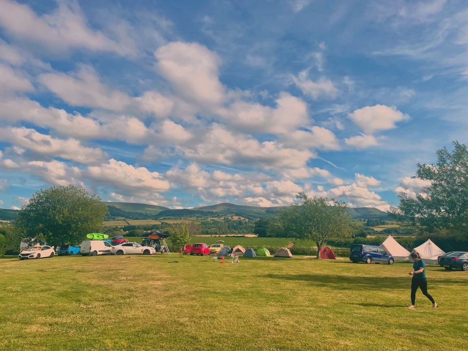 Tents in the field, hills beyond
