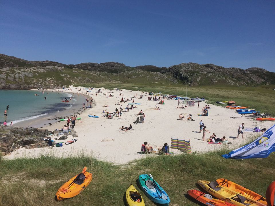 Busy sandy beach with kayaks