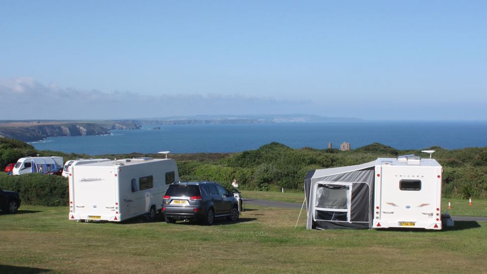 Caravans on grass with sea behind