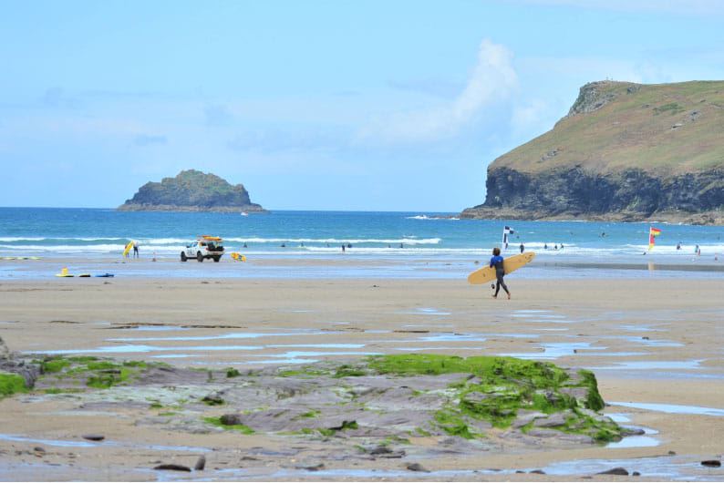 Beach with rocks and a surfer