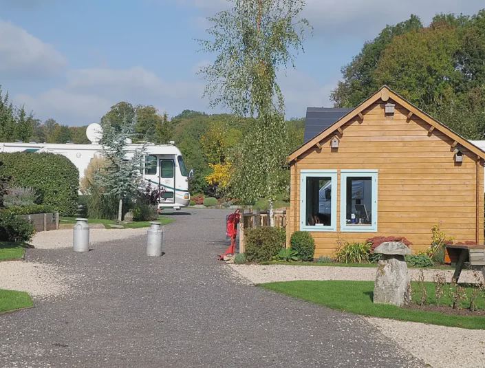 Motorhome pitches by a wooden cabin
