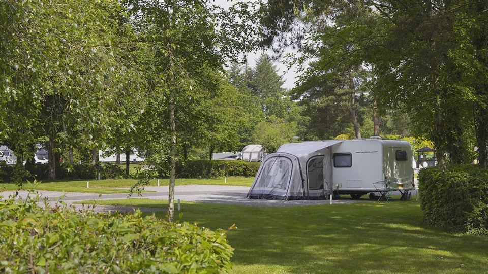 Caravan with awning under trees