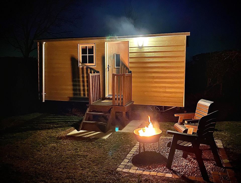 Shepherd's hut and fire pit at night