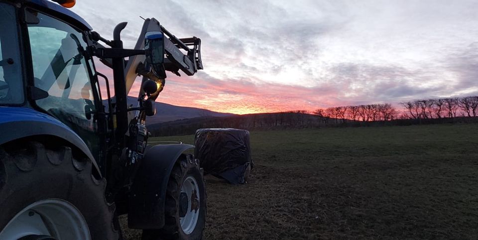 Tractor in the field at sunset
