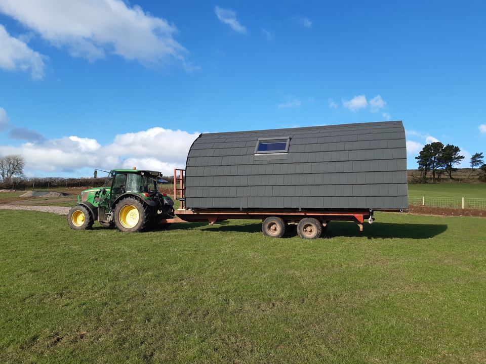 Shepherd's hut being towed across the field