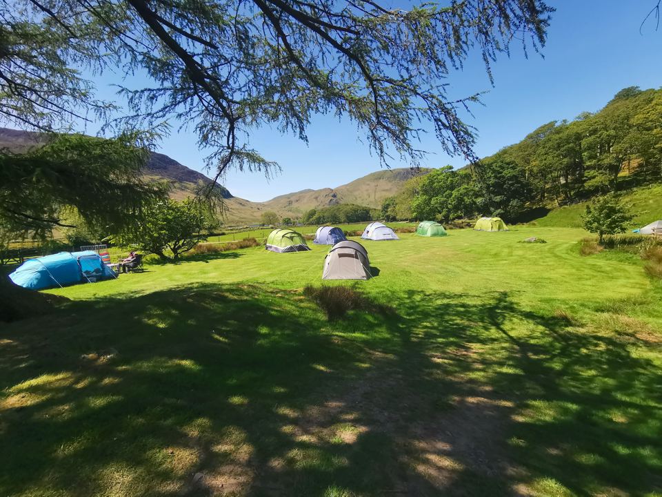 Tents on the grass below the fells