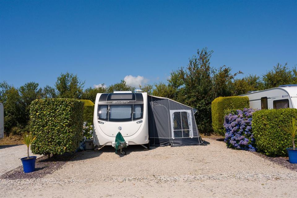 Caravan on gravel between hedges