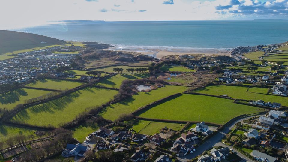 Aerial view across fields to the beach