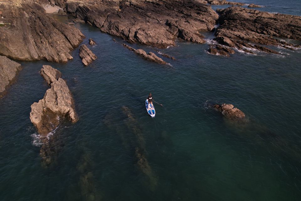 Paddleboarder among rocks