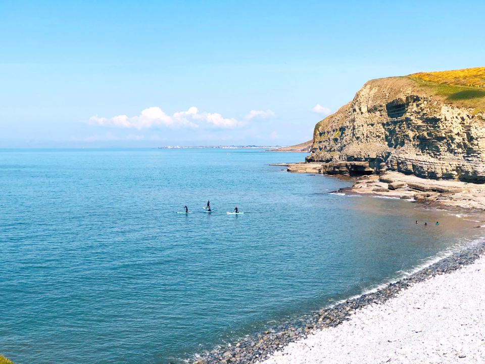 Cliffs and bay with paddleboarders