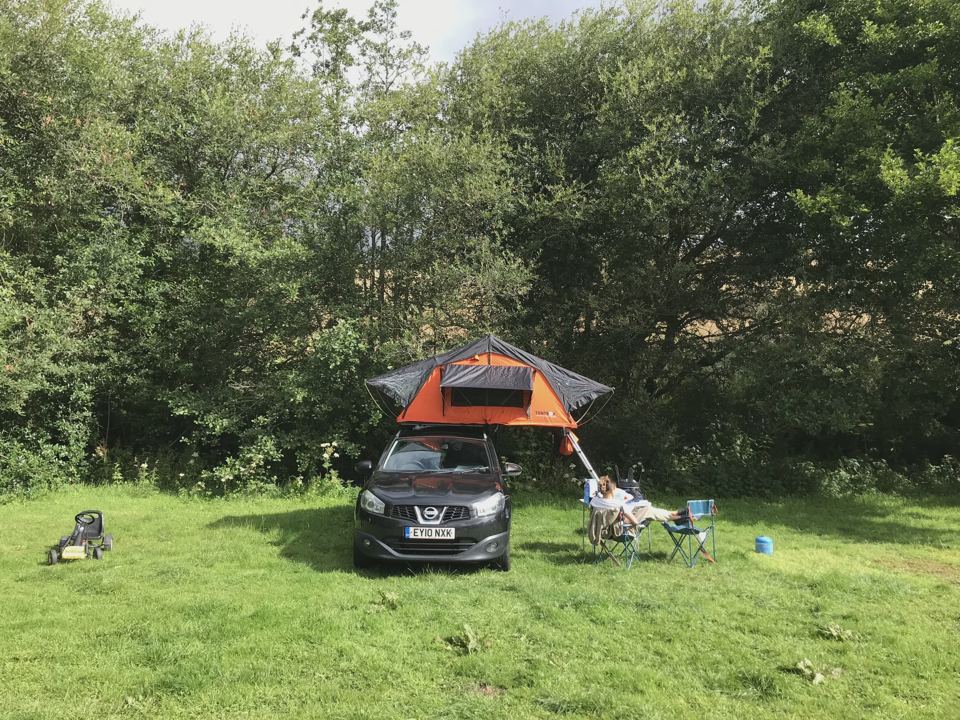 Car with a roof tent on the grass